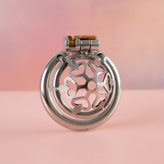 An angled side view of the Cage Of Hearts from House Of Chastity. You can see it fully assembled with its base ring and integral lock in place.