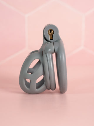 A side view of the Cobra Nub in grey, the flat base ring is fitted to the chastity cage and the integral lock is fixed in place.