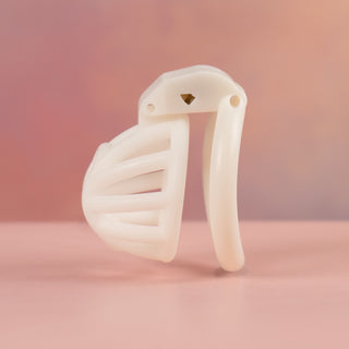 An alternate side view of the white Cobra Nub chastity cage, you can see the curved base ring and the depth of the cage.