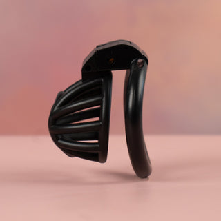 A side view of the black Cobra Nub cock cage, it shows the angled base ring.