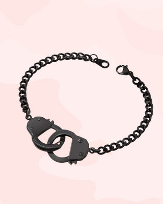 Black handcuffs on a chain with a pink gradient background