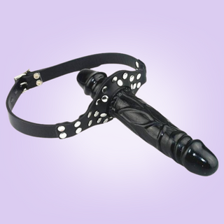 A full view of the double ended penis gag, you can see the two different penis lengths and the head strap that buckles closed.