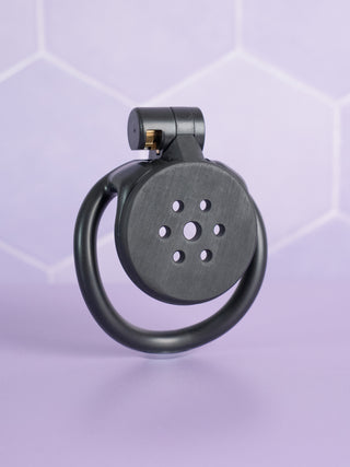The Flat Gatling Black with curved base rings from House Of Chastity, you can see the chastity cage from a side view with the integral lock fixed in place.