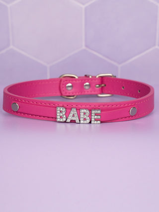 The hot pink choker with BABE in rhinestone lettering .
