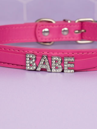 A close up of the rhinestone lettering on the hot pink choker
