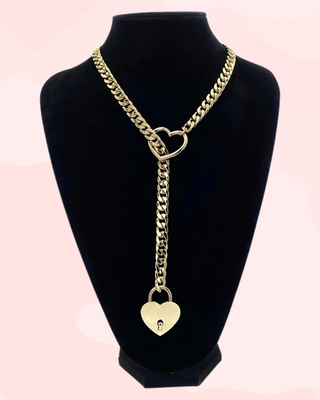 The Heart Slip Choker Chain is shown on a display model, you can see the gold slip chain, heart pendant and heart padlock, it is shown locked.
