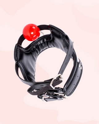 Black leather high necked collar with a red ball on a light pink background