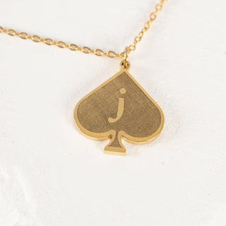 Close-up image of a Jack of Spades bracelet/anklet featuring a gold pendant, displayed on a white background