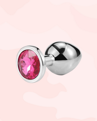 Jewelled anal plug with a rose pink gemstone on a pale pink background