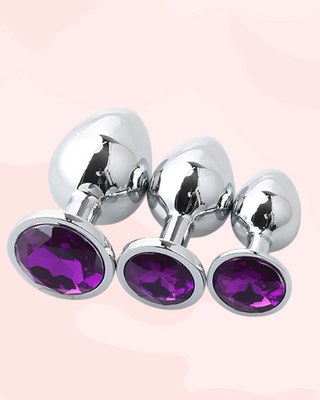 Three metallic anal plugs in small, medium and large, with purple gemstones