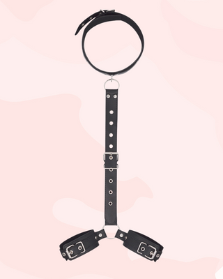 Black leather choker with attached cuffs on a pink background