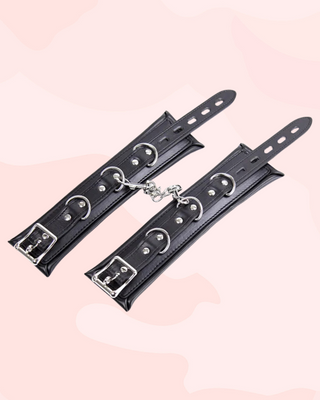 A flat view of the ankle cuffs, the adjustable straps, D-rings and chain can be seen clearly.