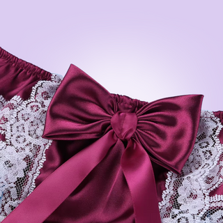 A close up of the large bow that decorates the back of the Satin and Lace Tanga panties. It is shown here in red wine colour.