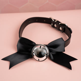 The black soft ribbon collar bow from House Of Chastity, shown is the pink collar, matching soft satin ribbon and silver bell perfect attire for any sissy.