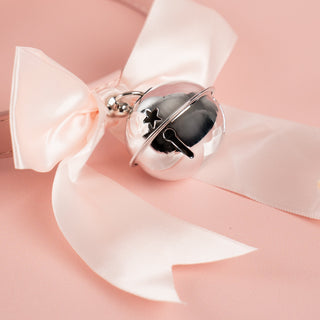 A close up of the soft ribboned bow and large silver bell
