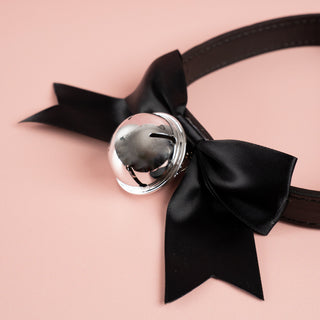 a close up of the black ribboned bow and bell