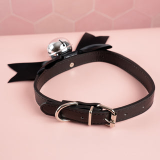 Showing the adjustable collar and buckle closure on the black satin soft bow collar.