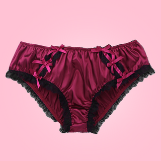 Shown unworn, Adult knickers for men, sissy, lgbt, unisex. Made in red wine satin with black lace detailing to the legs and panels on each side. There are also matching wine satin bows prettily applied.
