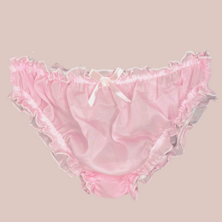 A close up of the soft pink see through bikini shaped panties for men, you can see the elasticated waist and legs, and the decorative matching pink bow.