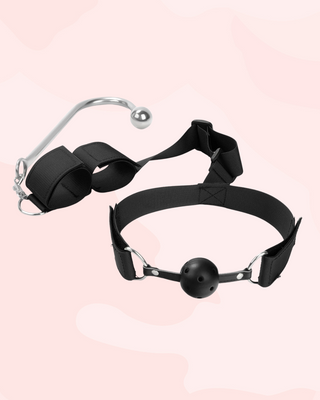 A close up of the black ball gag with breathable air holes, the adjustable velcro straps for the gag can be seen up close.