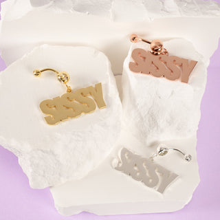 Sissy navel piercing displayed in three colour options: rose gold, silver, and gold. Each piece features a sleek, polished finish, showcasing its elegant and stylish design.