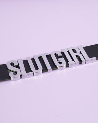 A picture of the slut girl collar in black laid out flat.