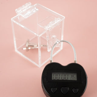 Showing the clear chastity key safe box, where you can see your chastity cage keys locked away nice and tight and you can't get to them. Also shown is the electronic lock that can be set on a timer for release.