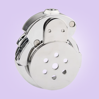 You can see the push button lock at the top of the chastity cage.