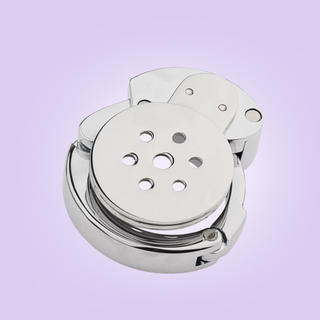 An angled view of the chastity cage, the adjustable base ring is closed