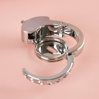 A side view of The Bridewell Chastity Cage, you can see the adjustable base ring has been locked in place and you can see the push lock button at the top.