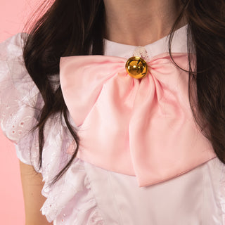 A close up of the removable bow with gold bell.