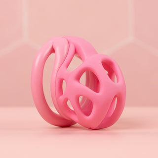 An angled view of the fully assembled chastity cage in pink
