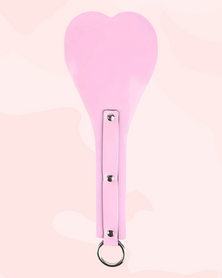 Pink paddle with a ring on a light pink background