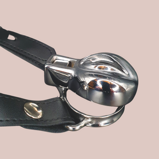 An angled image of the Pussy Steel, showing how the cage and base ring sit together whilst the belt which attaches via the base ring ears, allows for a secure fit.