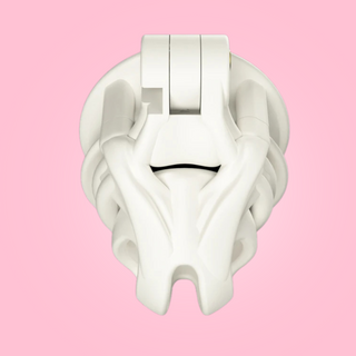 An over view of the white chastity cage fixed to its base ring, this is a white coloured cage.