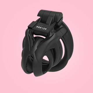 An angled view of the small chastity cage with the magic locker in place and a numbered tag.