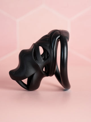 A full side profile of The Serpent Sentry chastity device, the cut out design to the cage body allows for airflow.