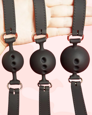 All three ball gag sizes being held by their adjustable straps