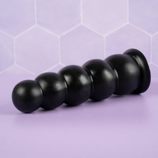 An angled view of the Amative dildo, you can see the smooth surface and get a good idea of the size of the beads.