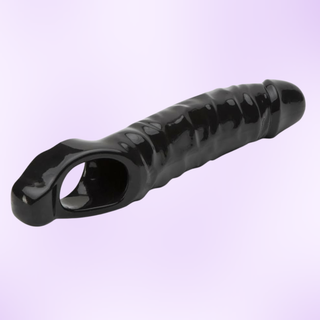 An angled view of the black penis sleeve on a purple background