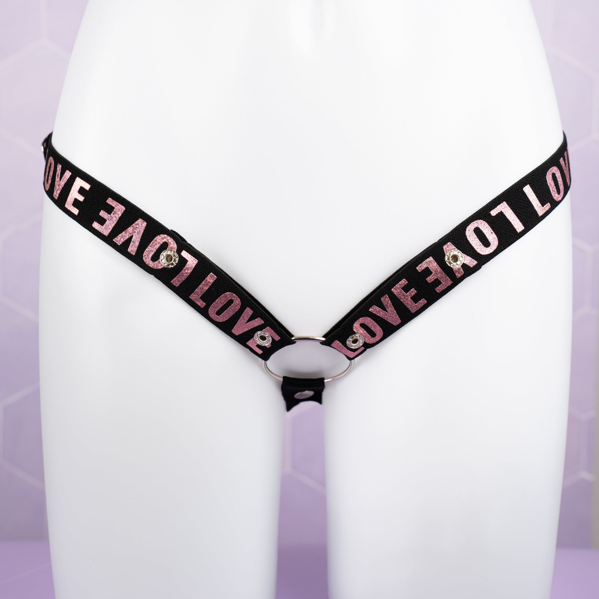 A front on view of the 3 Way Restraining Chastity Belt shown here in our pink. You can see the adjustable poppers and the included ring.