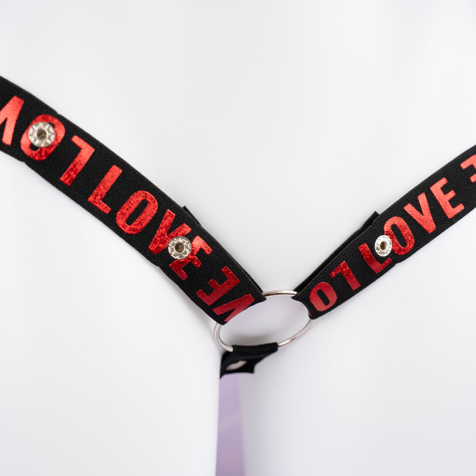 A close up of the shiny red print on the chastity belt.
