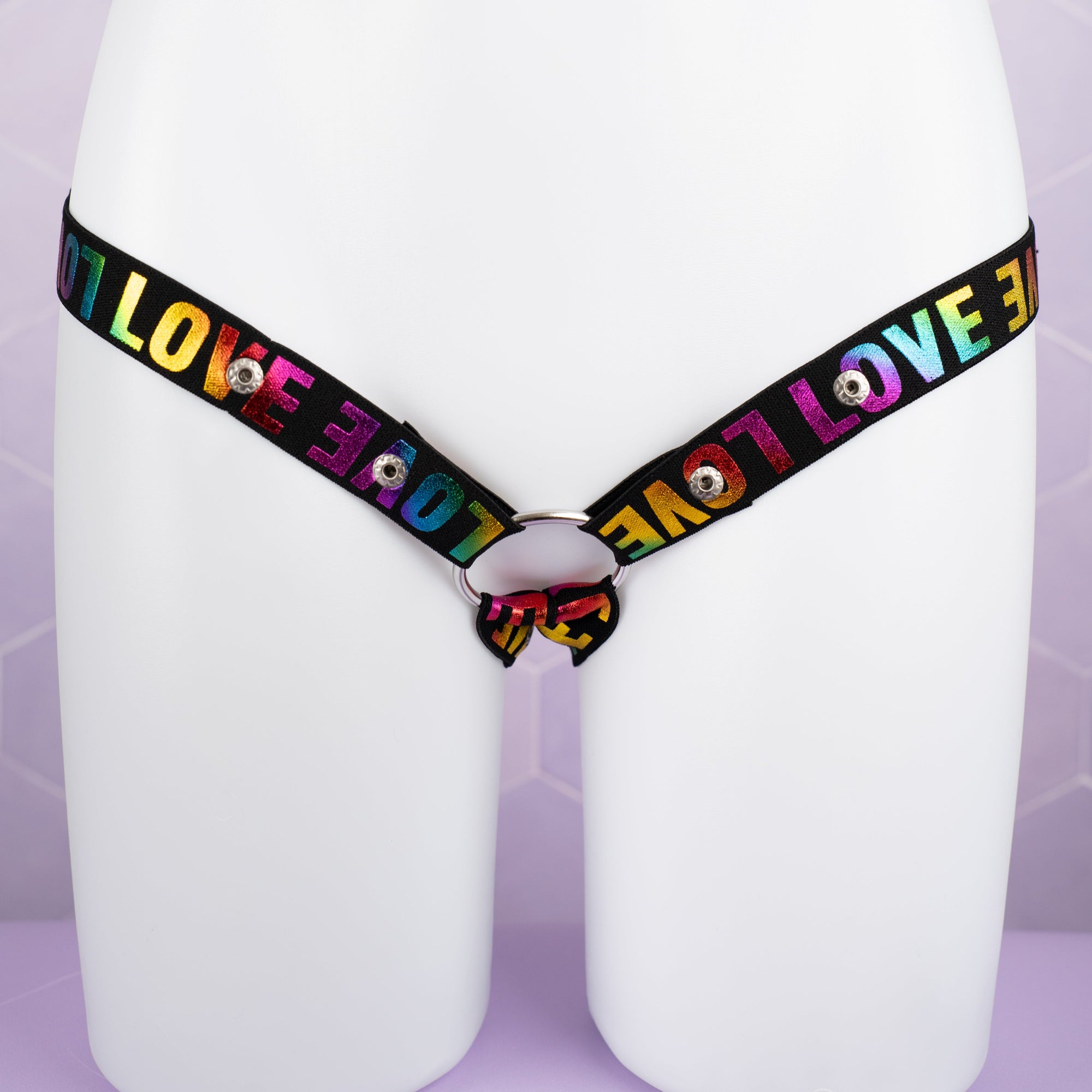 A front on view of the 3 Way Restraining Chastity Belt shown here in our multi-colour. You can see the adjustable poppers and the included ring.