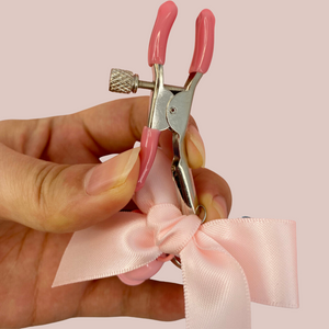 This image shows the nipple clamps beign held and showing how they can be opened and closed. The screw also allows for the adjustment to be locked in place.