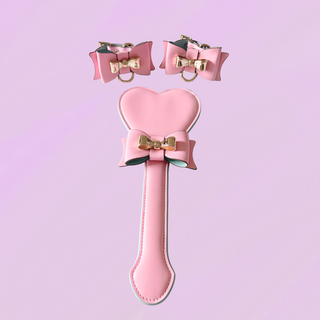 A close up of the wrist cuffs and paddle on a purple background