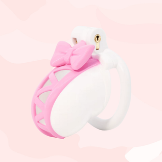 An angled view of the fully assembled chastity cage, the pink cut out lacing runs up the centre of the cage leading to the bow detailing.