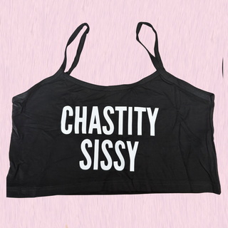 A black crop top with thin straps and the words 'CHASTITY SISSY' printed in bold white letters across the front, displayed flat against a light pink textured background.