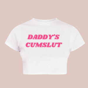 A white crop top t-shirt with Daddy's Cumslut printed in pink
