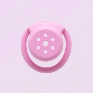 The chastity cage is shown front on in front of a soft pink background
