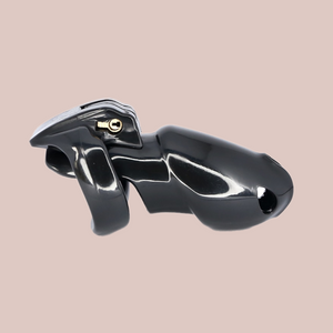 Shown is the black maxi cock cage that we offer in our version of the Holy Trainer range. It is shown from the side angle so that you have a full view of the assembled chastity cage, the cock cage is shown attached to a base ring and the integral lock is in place, showing how it fits to the body. This product is the black version, these cages also come in pink and clear.